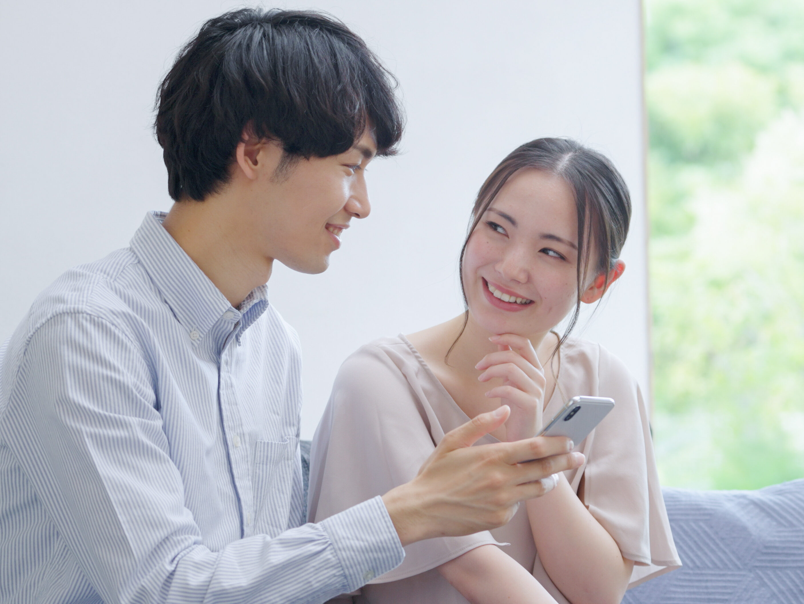 スマホを見る若い夫婦・カップル